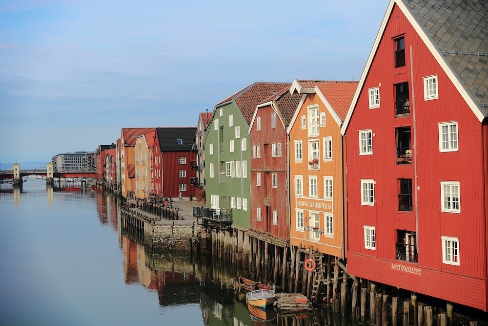 Colourful wooden houses along water. Photo.