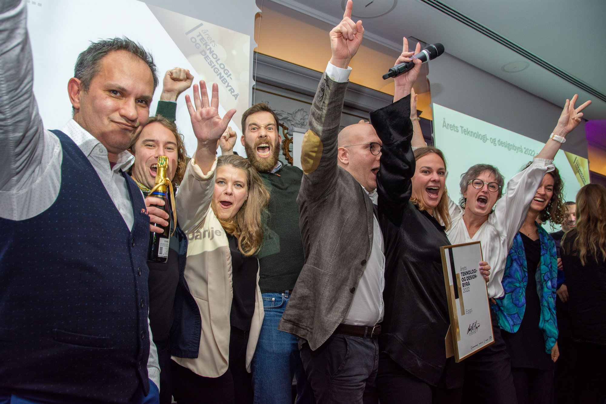 EGGS employees cheering while holding up the award for the best technology and design bureau in 2022. Photo.